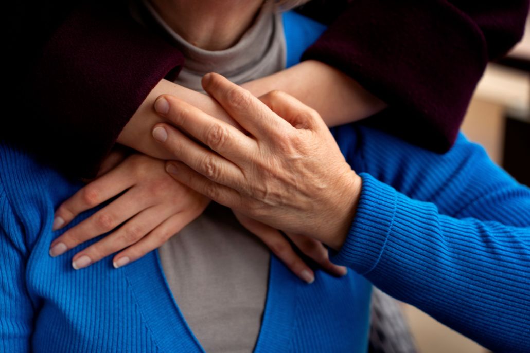 Focus su donna che abbraccia un uomo anziano di spalle|Primo piano intervistata